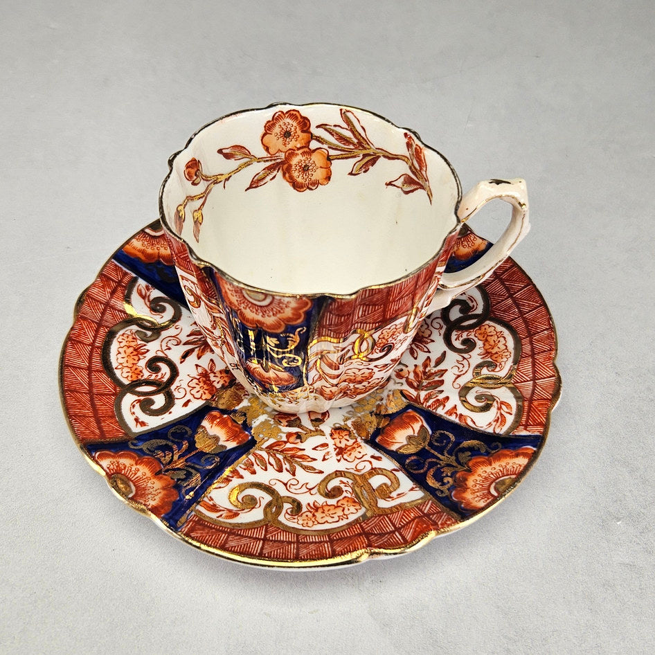 Pearce porcelain cup and saucer with gilt scroll decoration