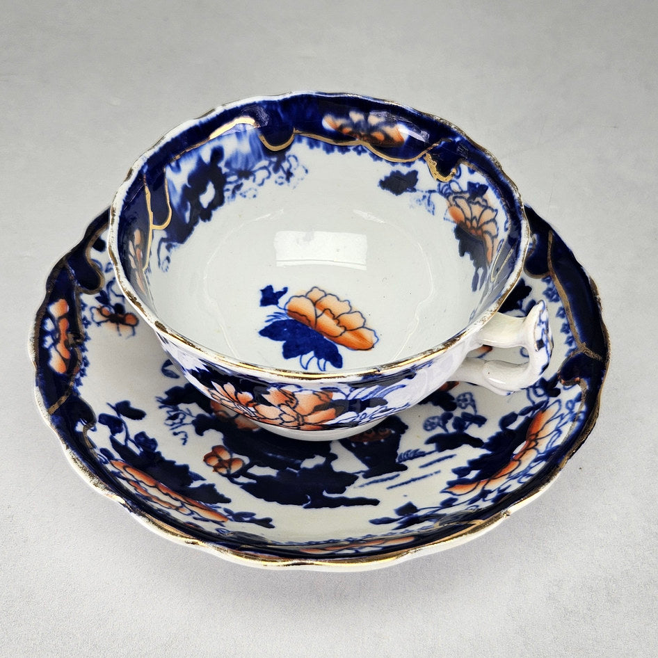 Flow blue cup and saucer with gilt rim details