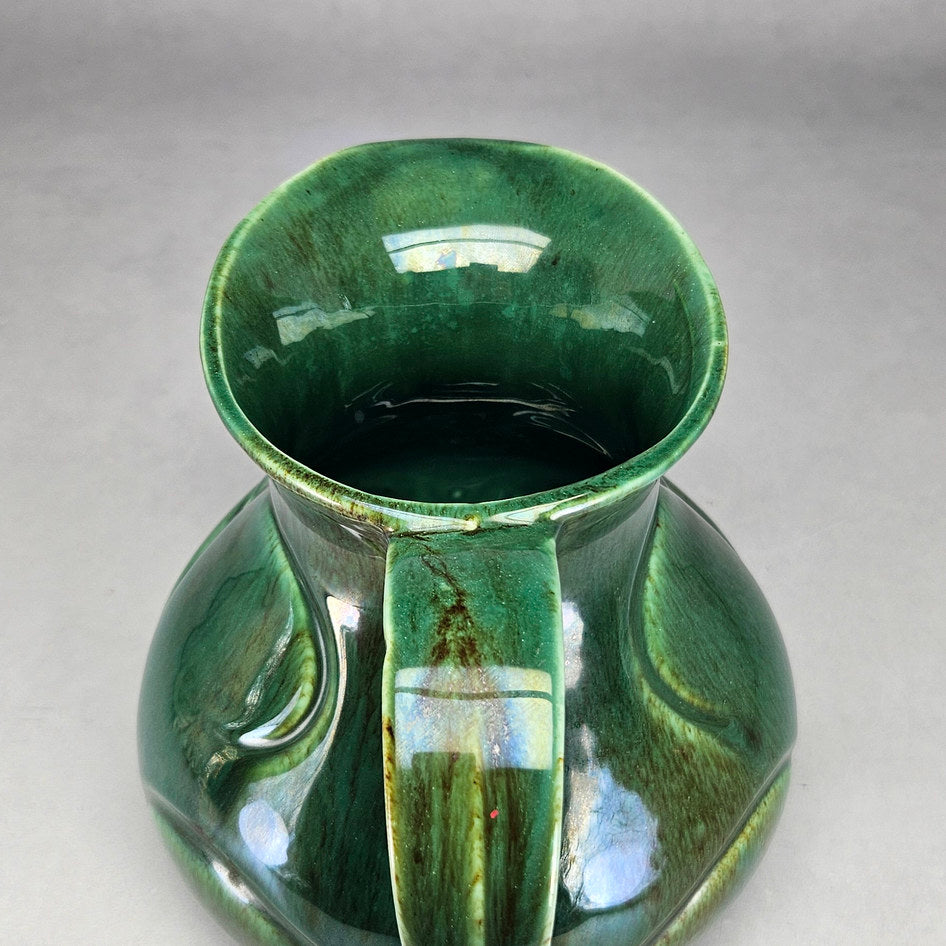 Lucia Ware green scroll jug viewed towards glazed opening