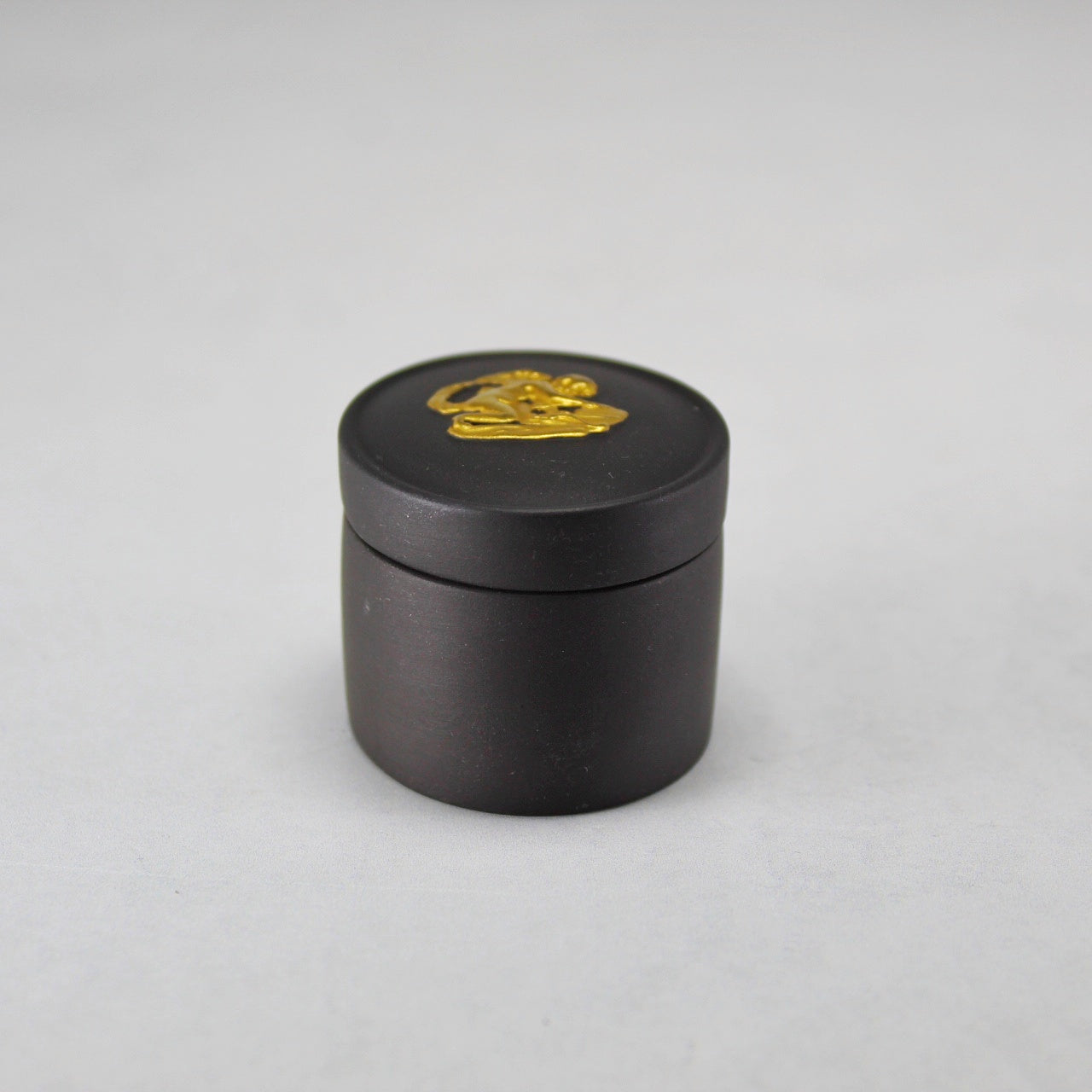 Wedgwood Gold on Black Jasperware Lidded Pill Box with Cherub Relief Figure