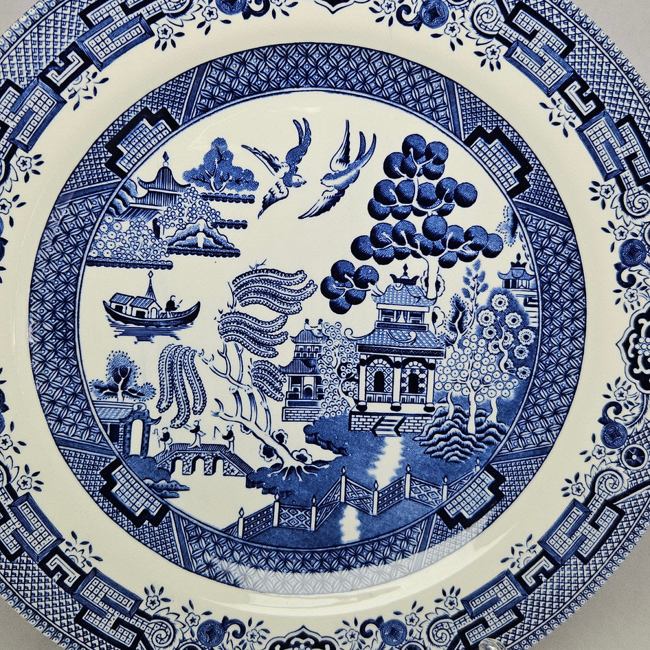 Churchill Blue Willow blue and white transferware dinner plate showing the classic willow pattern with pagoda, bridge and birds