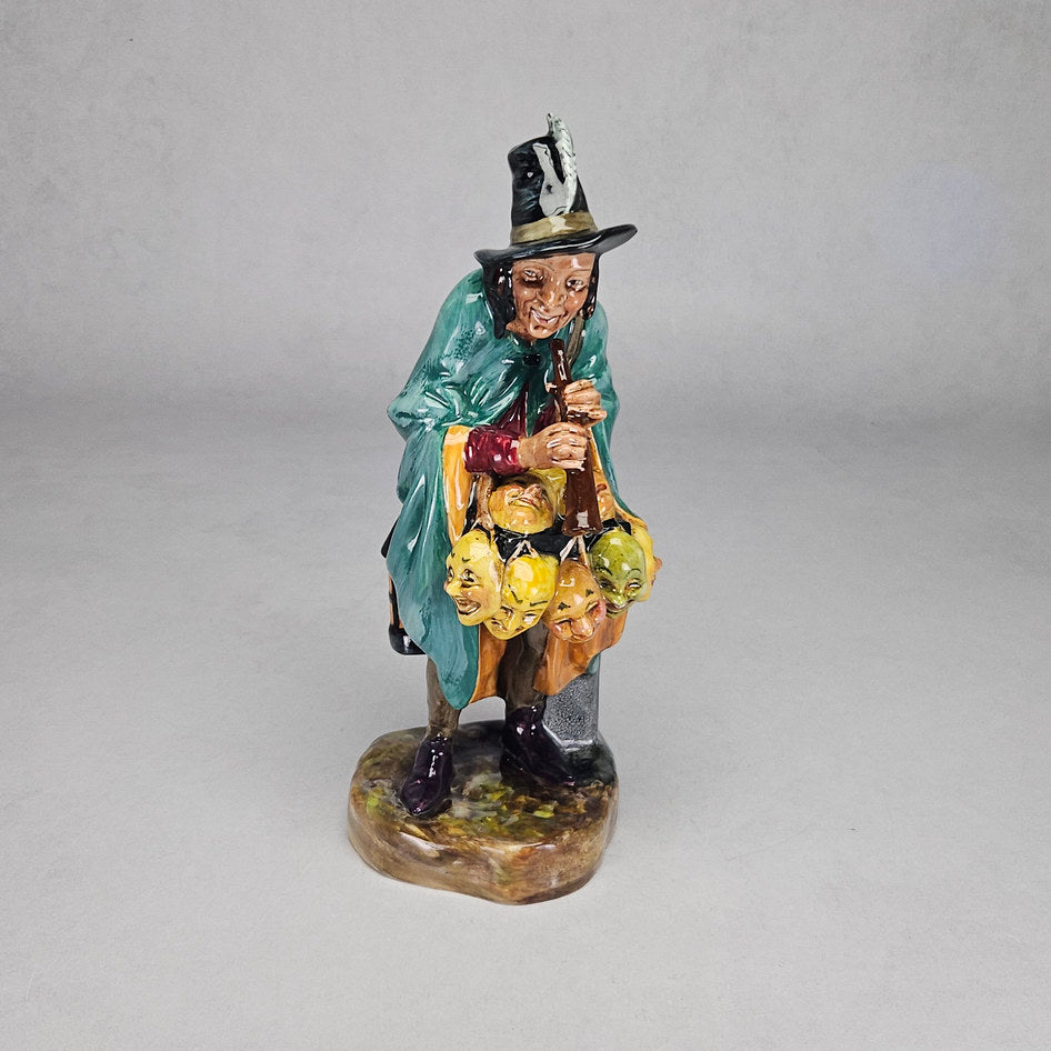 Royal Doulton The Mask Seller HN2103 figurine, a highly detailed character study in teal cape and feathered hat carrying colourful masks