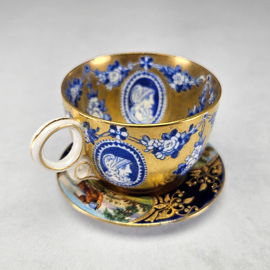 Gilt Coalport cup and saucer with cobalt cameo panels