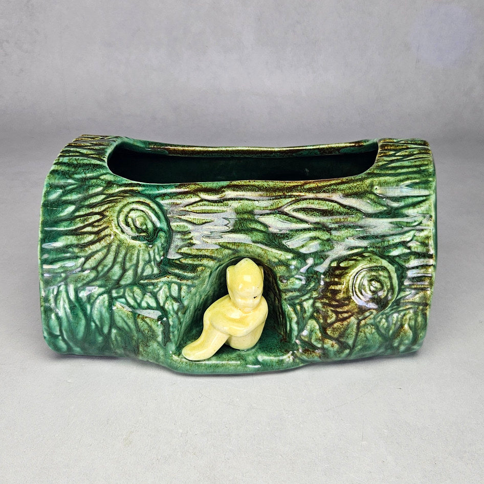 Vermont green log planter with small yellow seated figure