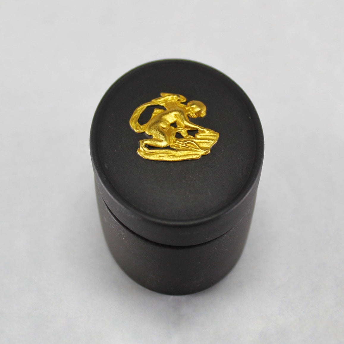 Wedgwood Gold on Black Jasperware Lidded Pill Box with Cherub Relief Figure